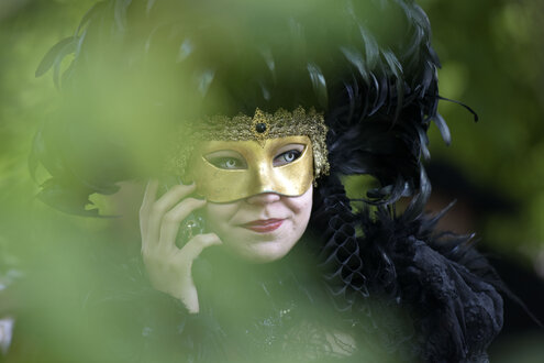 Eine Frau mit Kostümmaske telefoniert