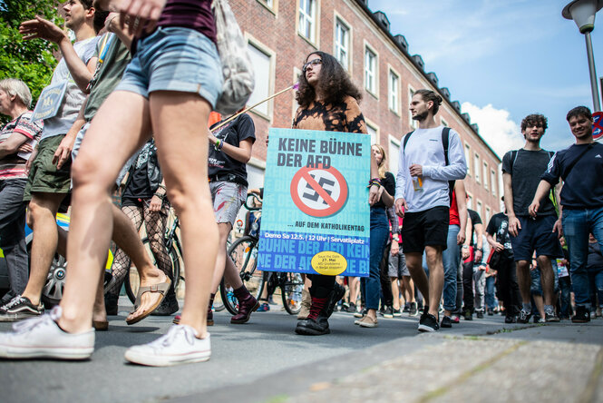 Eine Demonstrantin hält bei einer Demo ein Plakat mit der Aufschrift: "Keine Bühne der AfD" in den Händen.