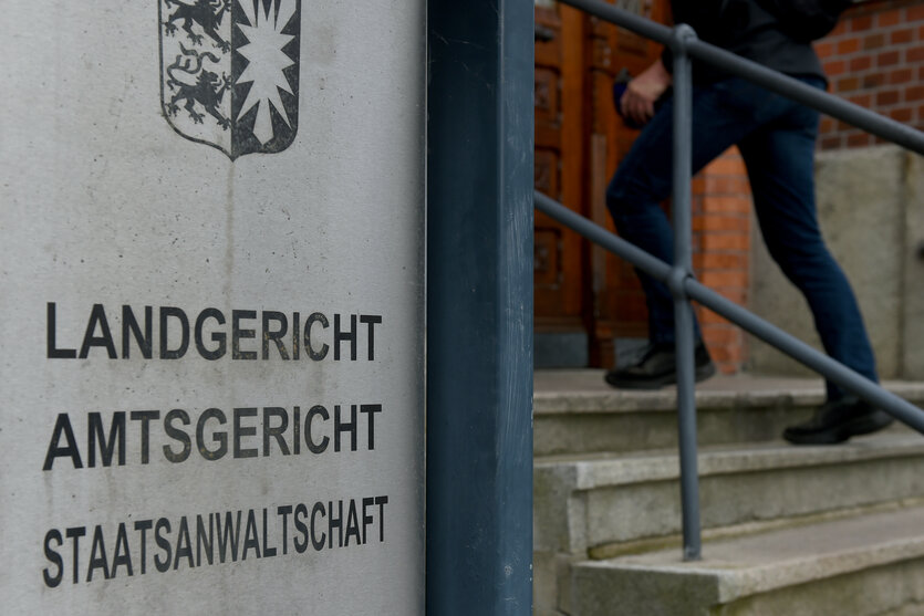 Auf einem Schild steht "Landgericht, Amtsgericht, Staatsanwaltschaft", darüber das Wappen Schleswig-Holsteins