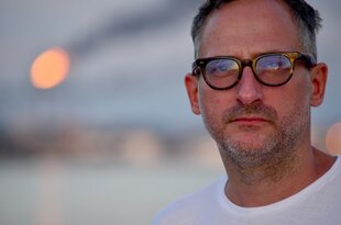 Mann in meittleren jahren mit Dreitagebart und Brille