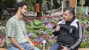 Muhannad Taha sitzt am Rand eines Blumenbeetes