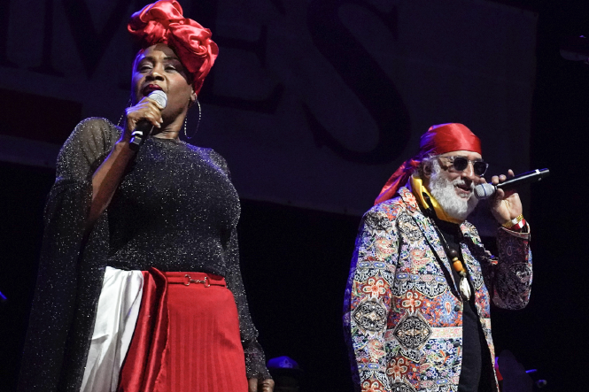 Lunise Exumé mit rotem Turban und rotem Rock und Richard A. Morse in einem farbenprächtigen Jacket bei einem Konzert