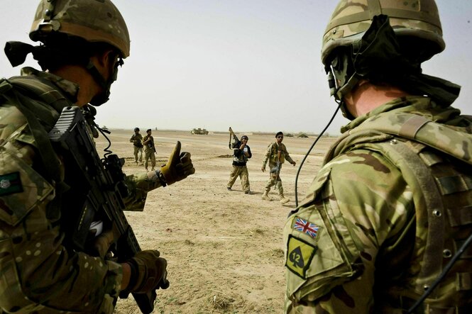 Daumen hoch: Zwei britische Soldaten grüßen afghanische Sicherheitskräfte, die im Hintergrund vorbei gehen
