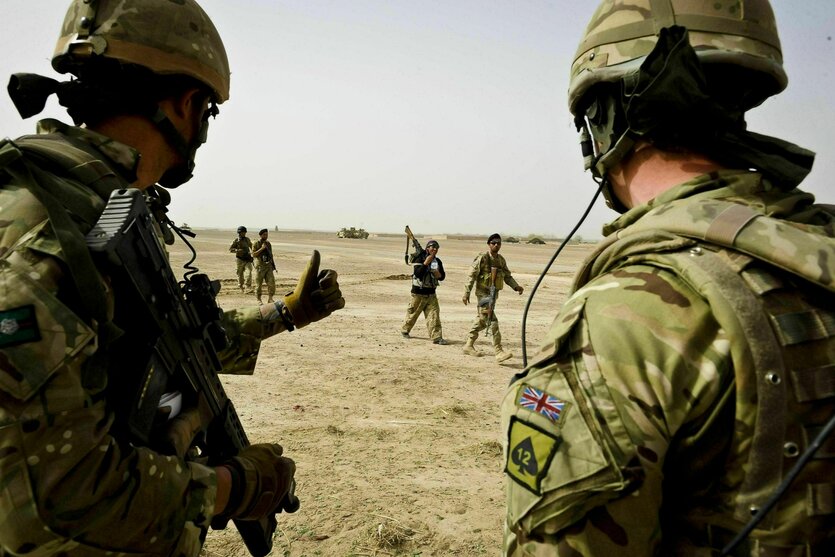 Daumen hoch: Zwei britische Soldaten grüßen afghanische Sicherheitskräfte, die im Hintergrund vorbei gehen