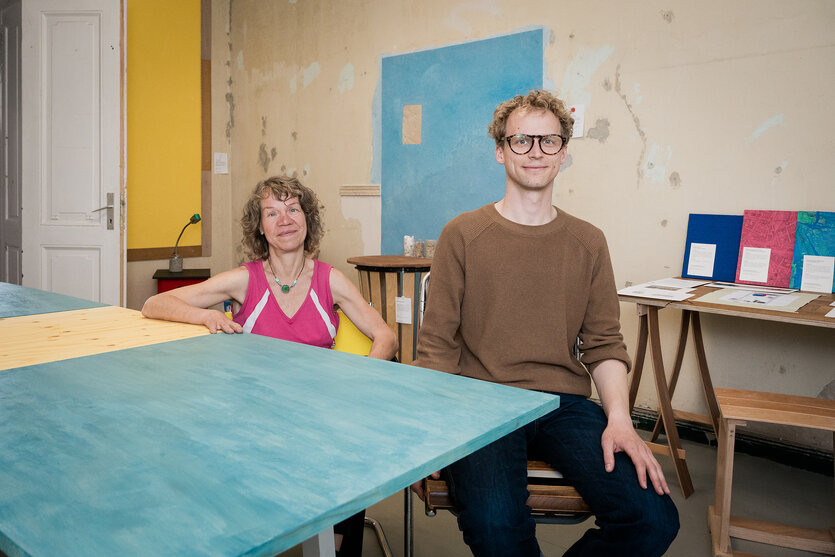Zwei Menschen in einer Wohnung am Tisch sitzend
