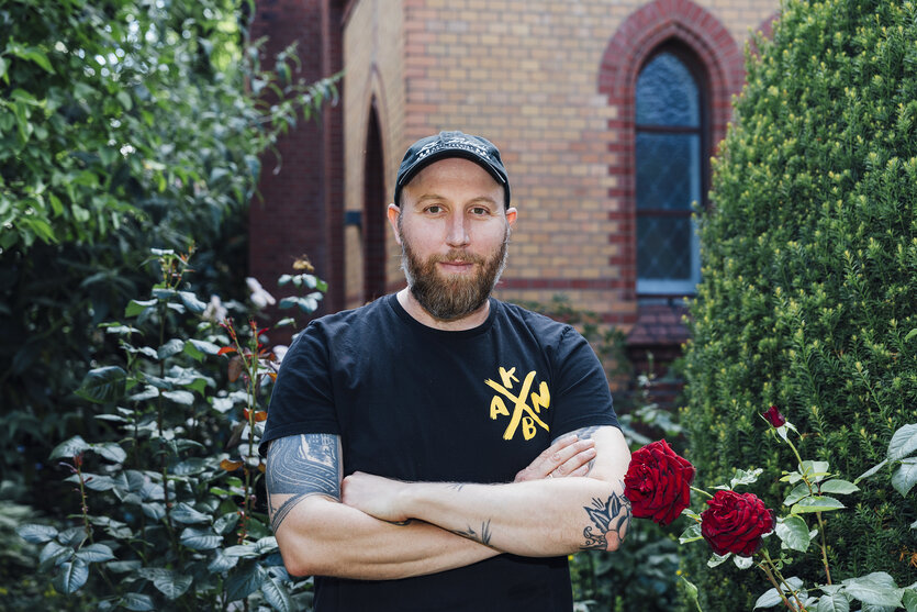 Portrait von Ulf Werner, der vor einer Kirche steht