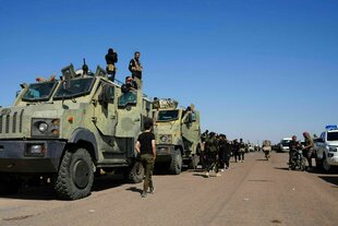 Militärfahrzeuge stehen hintereinander auf einer Straße