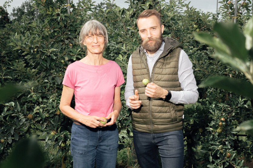 Die Obstbäuer*innen Anke Wollanik und Simon Noflatscher in einer Apfelplantage.