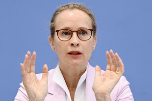 Eine Frau hält beide Hände vor ihre Schultern