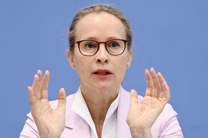 Eine Frau hält beide Hände vor ihre Schultern