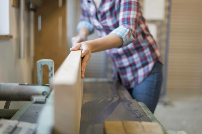 Eine Person arbeitet an einer Werkbank mit Holz