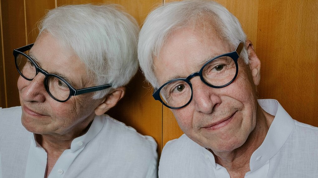 Ein Mann mit grauen haaren und sein Spiegelbild