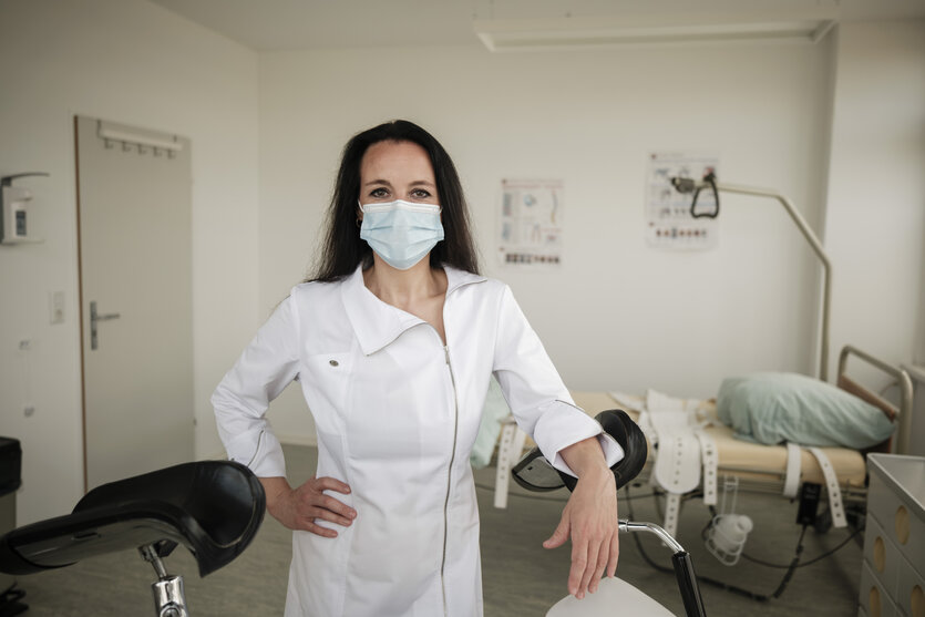 Portrait einer Frau im Arztkostüm und mit Mundschutz