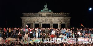 Viele Menschen auf der Mauer vor dem Brandenburger Tor 1989