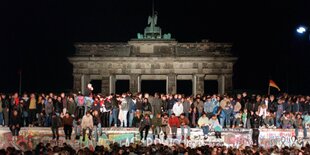 Viele Menschen auf der Mauer vor dem Brandenburger Tor 1989