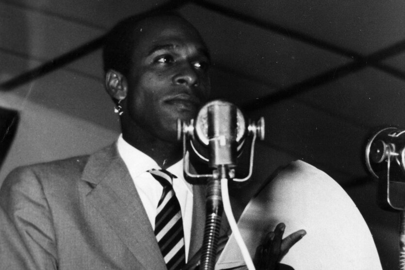 Frantz Fanon vor einem Mikrophon