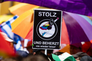Demonstranten halten ein Schild in die Höhe auf dem steht: STOLZ UND BEHERZT - nie wieder leise