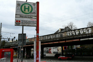 Eine Brücke, davor ein Bushaltestellenschild, auf dem "Sternbrücke" steht