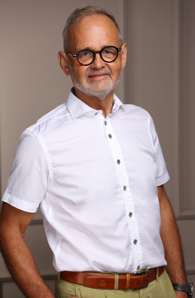 Ein Mann mit Brille lächelt in die Kamera