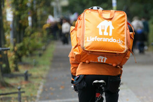 Lieferando Fahrer mit Rucksack von hinten