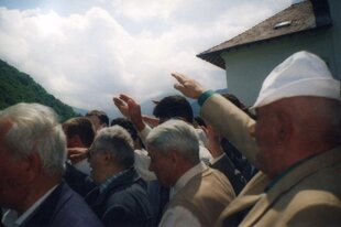 Männer stehen in einer Berglandschaft und heben ihre Arme zum faschistischem Gruß