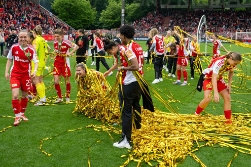 Fußballerinnen mit reichlich Lametta auf dem Rasen nach der Meisterinnenehrung