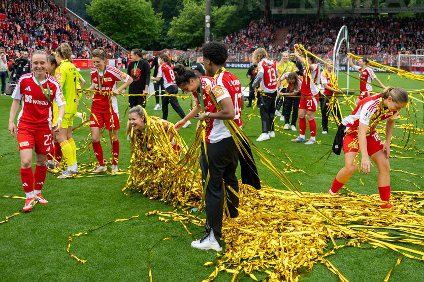 Fußballerinnen mit reichlich Lametta auf dem Rasen nach der Meisterinnenehrung