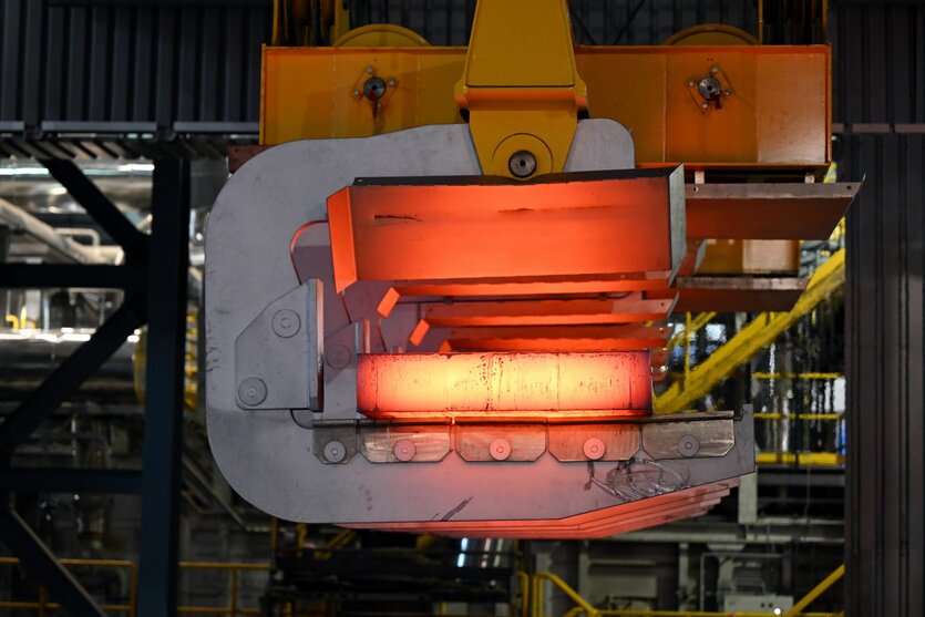 Eine glühende Bramme wird mit einem Kran aus der Stranggießanlage bei Thyssenkrupp Steel transportiert.