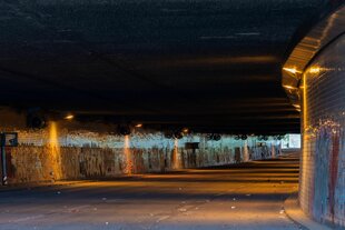 ein dunkler, dreckiger straßentunnel in berlin, am ende etwas tageslicht