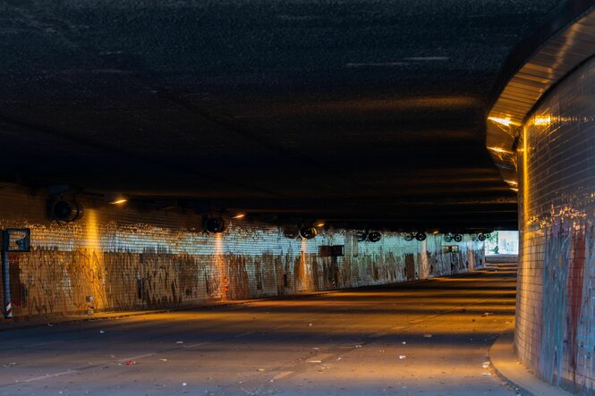ein dunkler, dreckiger straßentunnel in berlin, am ende etwas tageslicht