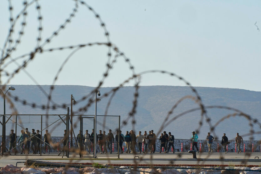 Geflüchtete hinter Stacheldraht an einem Hafen auf Kreta