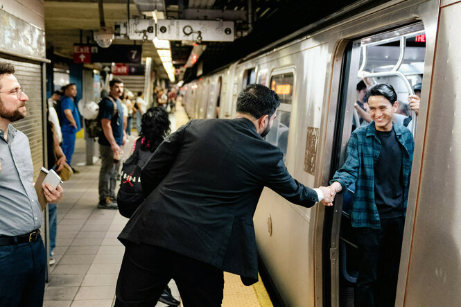 Bürgermeisterkandidat Zohran Mamdani begrüßt jemanden in der U-Bahn.
