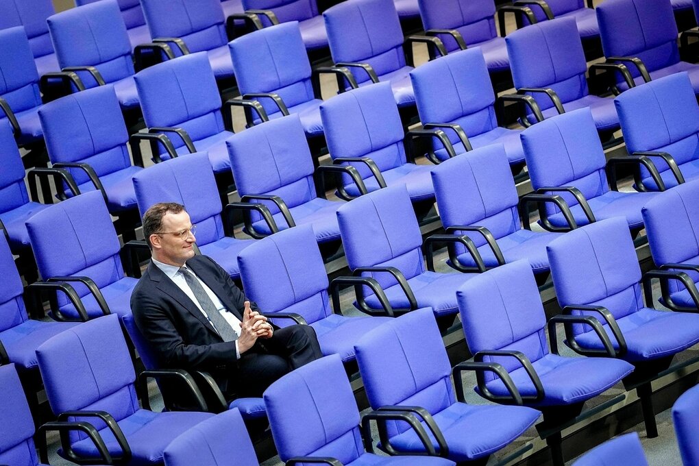 Jens Spahn sitzt ganz allein in den leeren Sitzreihen des deutschen Bundestags