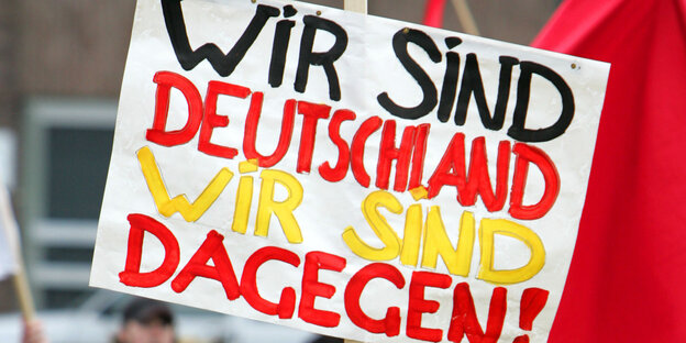 Schild, auf dem "Wir sind Deutschland. Wir sind dagegen." steht.