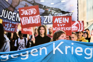 Junge Menschen halten Schilder und Banner