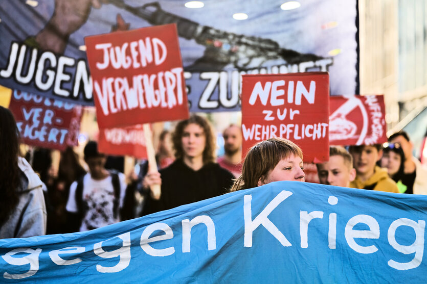 Junge Menschen halten Schilder und Banner