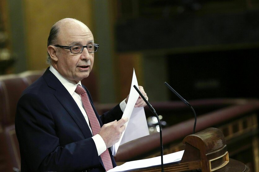 Der spanische Finanzimister Cristobal Montoro hält eine Rede im Parlament, er hält das Manuskript in der Hand. Der Mann ist Brillen- und Halbglatzen- und Krawattenträger