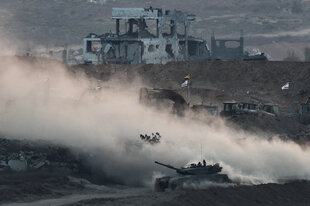 Ein Panzer fährt in Gaza an Ruinen vorbei.