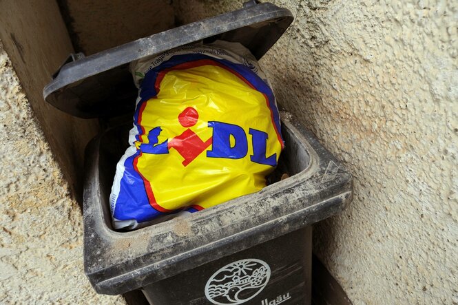Eine Lidl-Tüte in einer Mülltonne.