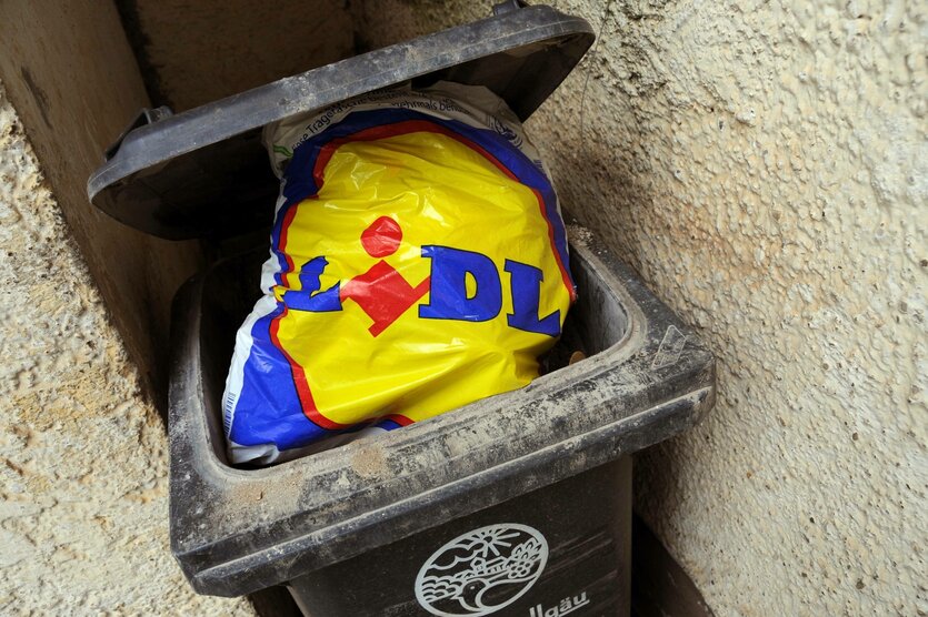 Eine Lidl-Tüte in einer Mülltonne.