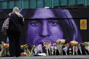 Blumen an einer Wand mit einem Bild von Ozzy Osbourne