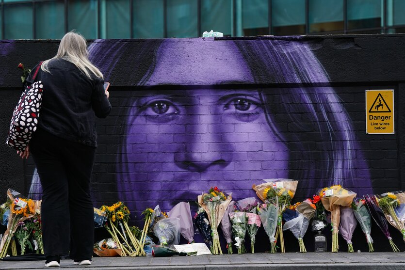 Blumen an einer Wand mit einem Bild von Ozzy Osbourne