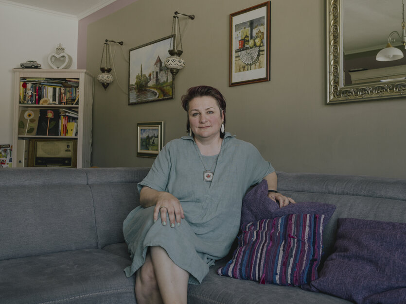 Aida Demirović-Krebs sitzt auf ihrem Sofa und lächelt