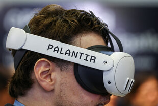 Person mit Bart von der Seite mit 3D Brille auf, darauf steht Palantir