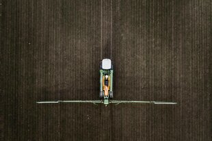 Eine Selbstfahrspritze, aufgenommen beim Verteilen von Pflanzenschutzmittel auf einem Feld