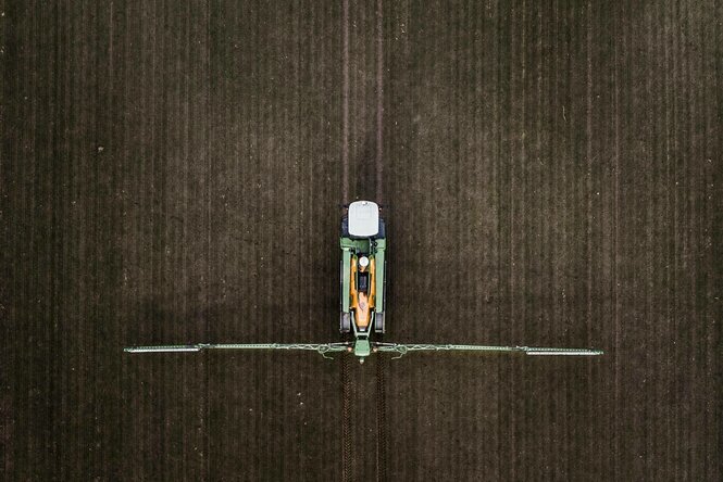 Eine Selbstfahrspritze, aufgenommen beim Verteilen von Pflanzenschutzmittel auf einem Feld