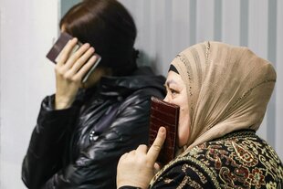 Zwei Personen halten sich ihre Pässe vors Gesicht.