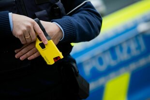 Polizist hält seinen Teaser bereit