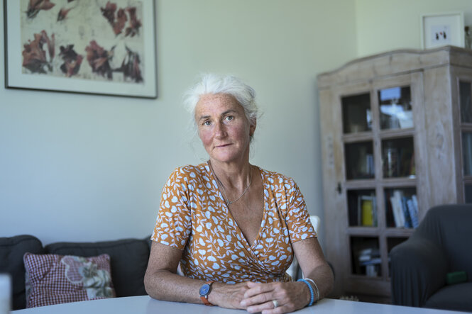 Porträt von Britta Flaig, an einem Tisch sitzend