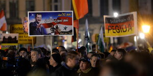 Pegida-Anhänger mit Plakaten auf dem Theaterplatz in Dresden